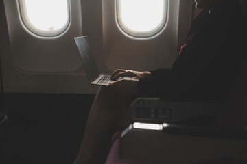 Blonde female tourist checking incoming notification on smartphone sitting on seat of airplane with...