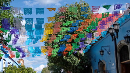 Colorful Day of the Dead flags hanging above the street in Oaxaca, Mexico - obrazy, fototapety, plakaty