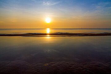 Sunrise on water in morning at beach Bang Boet