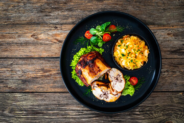 Baked rabbit saddle and vegetable salad on wooden table
