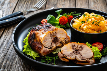 Baked rabbit saddle and vegetable salad on wooden table
