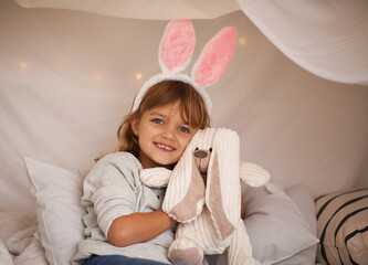 Girl, kid and bunny ears with teddy bear, soft toys and playing in fort for camping and fun at...