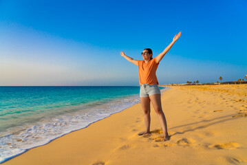 Fototapeta na wymiar Beautiful mid-adult woman standing on sunny beach