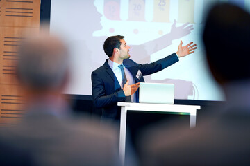 Business man, presentation and pointing at projector screen, conference or workshop with laptop for...
