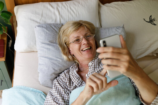 A senior woman with a phone in the morning