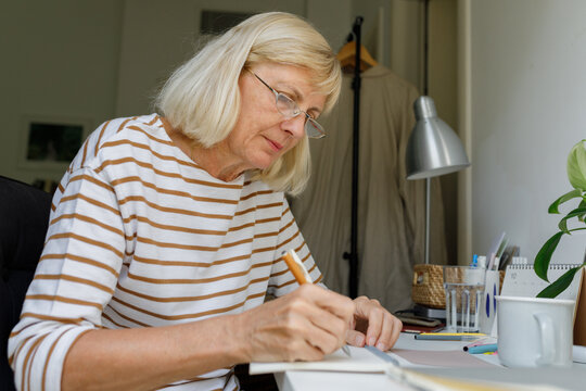A senior person writing in a notebook