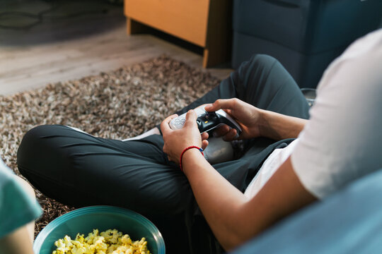 Unrecognizable person playing video games at home.