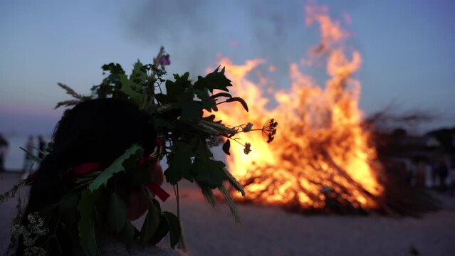 Bonfire. Feast of Saint Hans. A woman in a wreath looks at the fire.