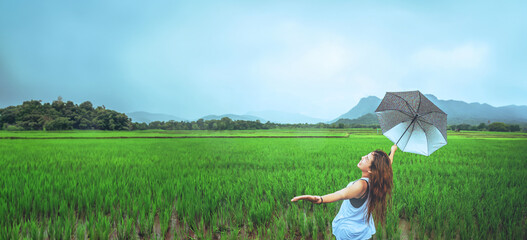 Asian women travel relax in the holiday. Women stand in rain umbrellas. On the meadow During the rainy season.Thailand - 759503082