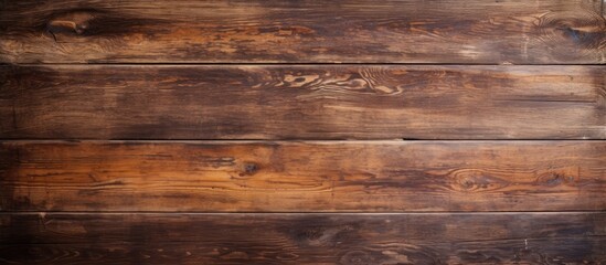 A closeup shot of a brown hardwood table with a wood stain, showcasing the beautiful pattern of the wooden plank. The blurred background highlights the rectangle shape of the table - obrazy, fototapety, plakaty