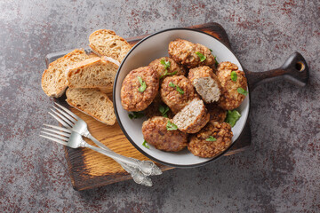 Dietary Buckwheat meatballs made of minced beef and boiled buckwheat porridge with onions, spices close-up in a plate on the table. Horizontal top view from above