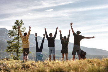 Group of playful happy friends are having fun in mountains and enjoys sunset view - obrazy, fototapety, plakaty
