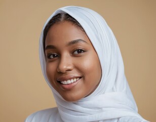 An african american muslim smiling young woman wearing a wearing white hijab.