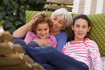 Fototapeta premium Senior woman, grandchildren and hammock in garden with smile to relax for retirement, break and enjoy. Portrait, girls and happy in home in summer or hot weather for school holiday with grandma