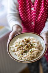 The hands of a senior home cook hold a plate with a national Slovak dish: Strapacky - Bryndzove Halusky - 759529266