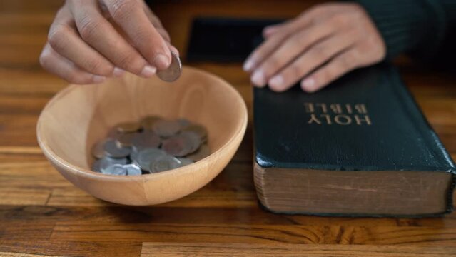 Close up hands people church congregants placing Money on an offering basket.