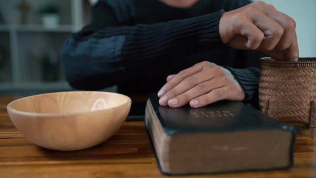 Close up hands people church congregants placing Money on an offering basket.