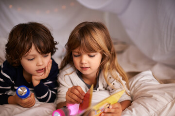Obraz na płótnie Canvas Reading, blanket fort and children with book for knowledge, learning and education with flashlight. Bonding, relaxing and young kids enjoying story or novel together in tent for sleepover at home.