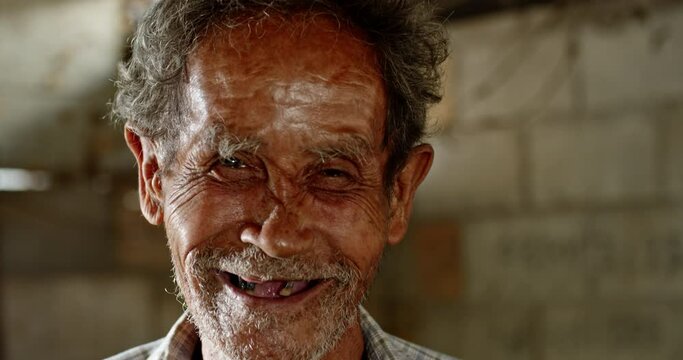 A smiling Asian man who is an elderly ragpicker or has a career collecting garbage and selling it, live in a slum village