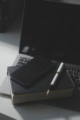 Office workplace with text space, White wooden table with office supplies tablet, desktop computer and book, top view, over light