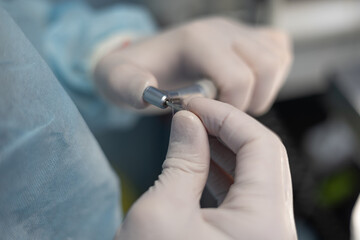 A veterinarian is changing the attachment on a fluoride treatment machine. The dentist puts on a...