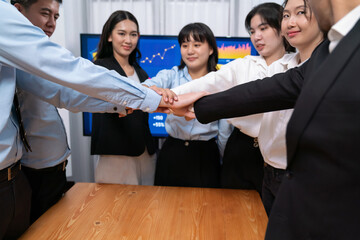 Multiethnic business people holding jigsaw pieces and merge them together as effective solution...