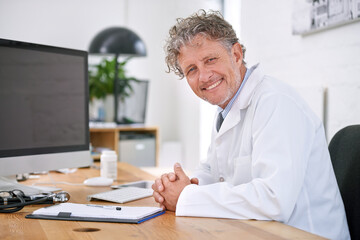 Mature man, doctor and smile portrait in office for healthcare, medical support and medicine career for administration. Senior, face or health expert with confidence or happy for cardiology in clinic