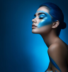 Fashion editorial Concept. Closeup portrait of stunning pretty woman with chiseled features, blue Cobalt paint body makeup. illuminated dynamic composition dramatic lighting. copy text space