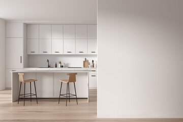 White kitchen interior with island and blank wall