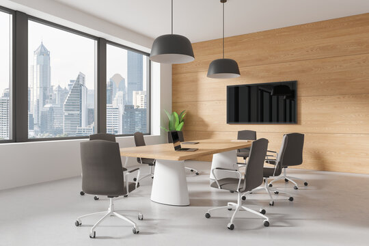 Modern office interior with meeting table and chairs, tv screen and window