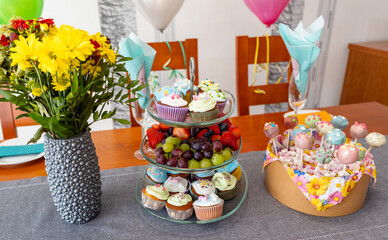 seblstgemachte Cupcakes und Cakepops, dazu frisches Obst und Blumen