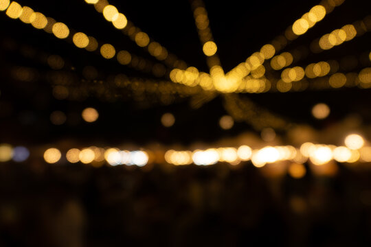 A blurry image of a crowd of people with lights shining on them