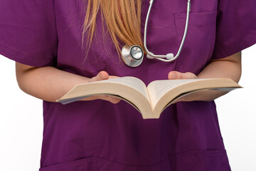 Pani doktor trzyma w dłoniach otwarta książkę, czyta i studiuje  - obrazy, fototapety, plakaty