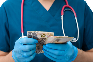 Pielęgniarz trzyma w dłoniach pieniądze i liczy - obrazy, fototapety, plakaty