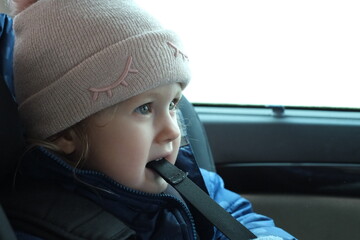 little girl in the car, warmly dressed, travel