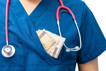 Pieniądze z łapówki wystające z kieszeni w lekarskim kitlu 