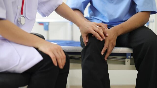 Doctor diagnoses the cause of osteoarthritis and knee pain of a male patient in an examination room at a hospital.