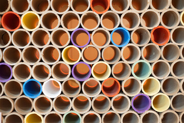 A beautiful background of plastic pipes in a section folded in a stack. Plastic tubes lie on top of each other forming a beautiful abstract background. Plastic pipes in a pile.