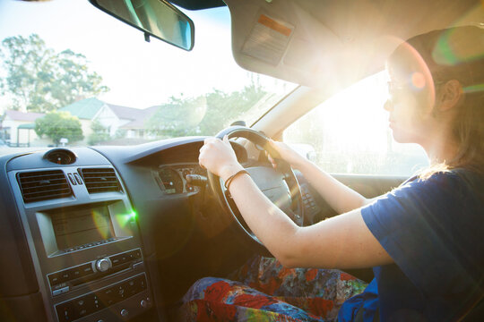 Sun flare over learner driver driving car through town