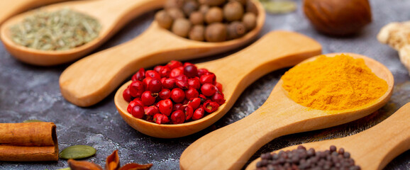 A set of spices on a gray background. Variety of spices from India. Food decoration design. Various spices, peppers and herbs close-up top view. Set of peppers, salt, herbs and spices for cooking.