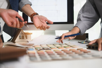 Cropped shot of designers choosing color swatches for interior renovation at office table