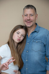 proud daddy, father is posing with his daughter in front of brown background