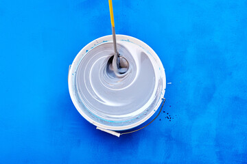 Tinting and mixing paint with stirring rod or mixer for paints, house painter added toner pigment...