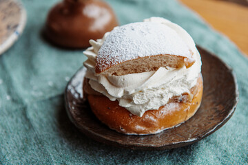 Typical Swedish semla with sweet cream on te blue textile