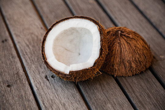 Coconut on wood cut in half with white flesh