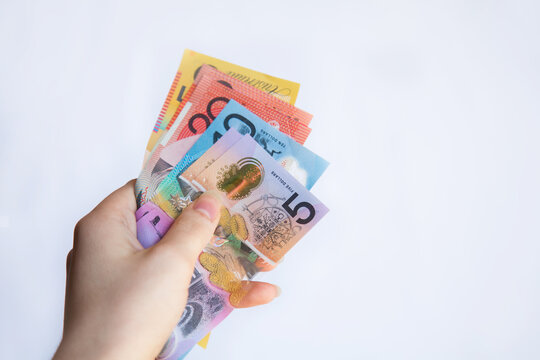 Hands holding notes of Australian money five, ten, twenty and fifty dollar notes