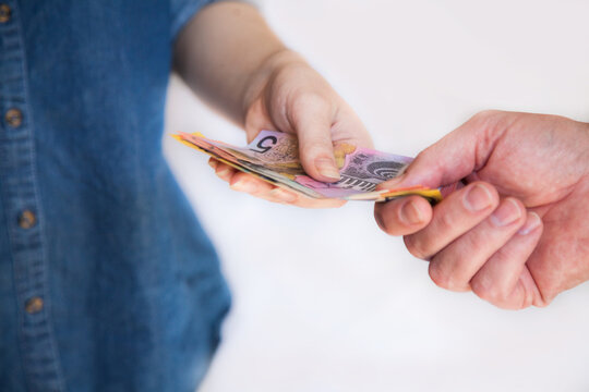 People handing over Australian money notes in payment