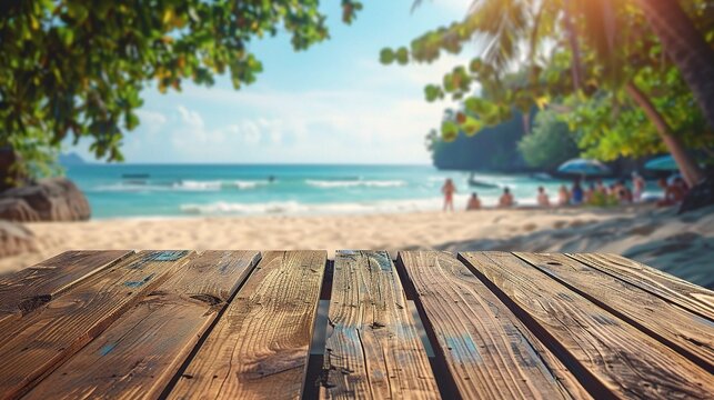 Wood table top on blurred beach background with people in colorful 