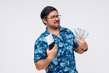 A cocky male tourist in a Hawaiian shirt flaunting money and a boarding pass, isolated on a white...