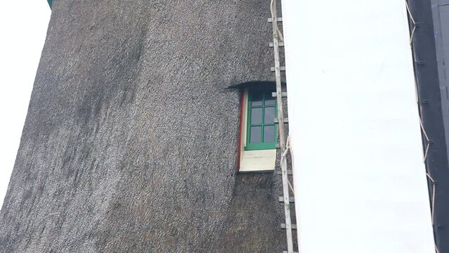Detalle de la ventana de un molino de viento hist&oacute;rico holand&eacute;s al tiempo que giran sus aspas. 